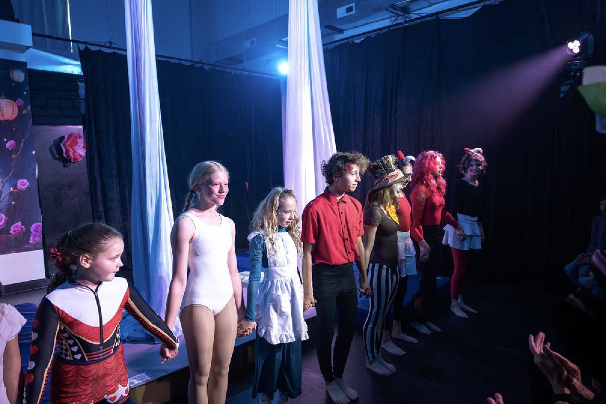 Young Luna performers bowing in a line under the stage lights